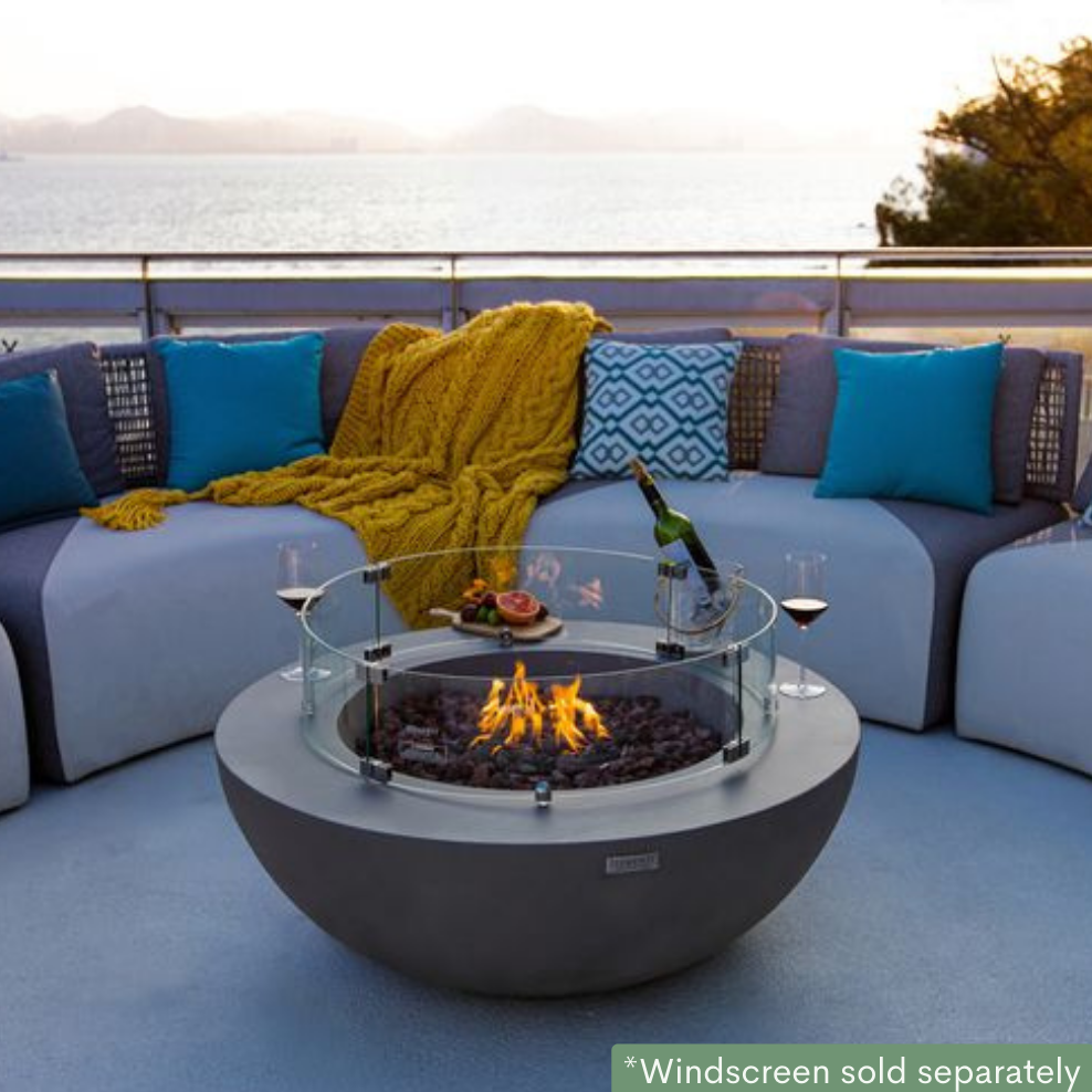 Elementi Lunar Bowl Fire Pit Table - Light Gray Lit in a Porch with a Ocean and mountain view